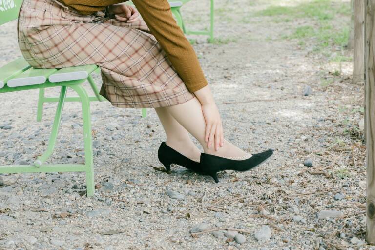足が気になっているヒールの女性