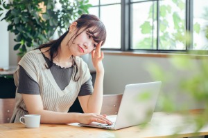 パソコンの前で頭を抱える女性