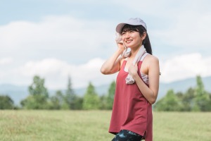 汗を拭く赤いタンクトップの女性