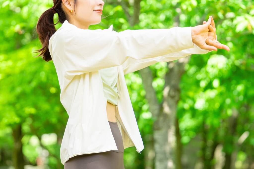 自然の中でストレッチをする女性