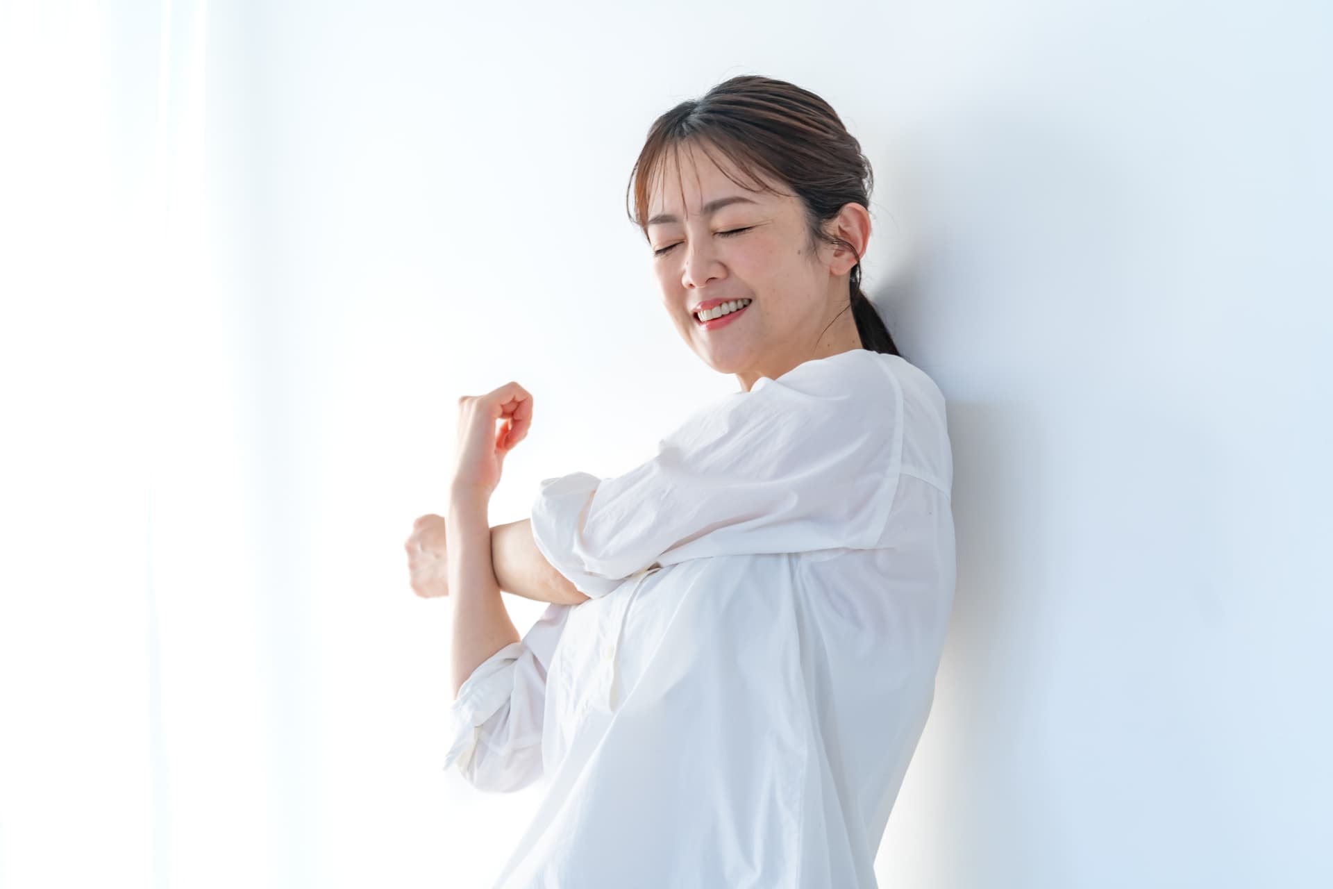 ストレッチをして腕を伸ばす中年女性