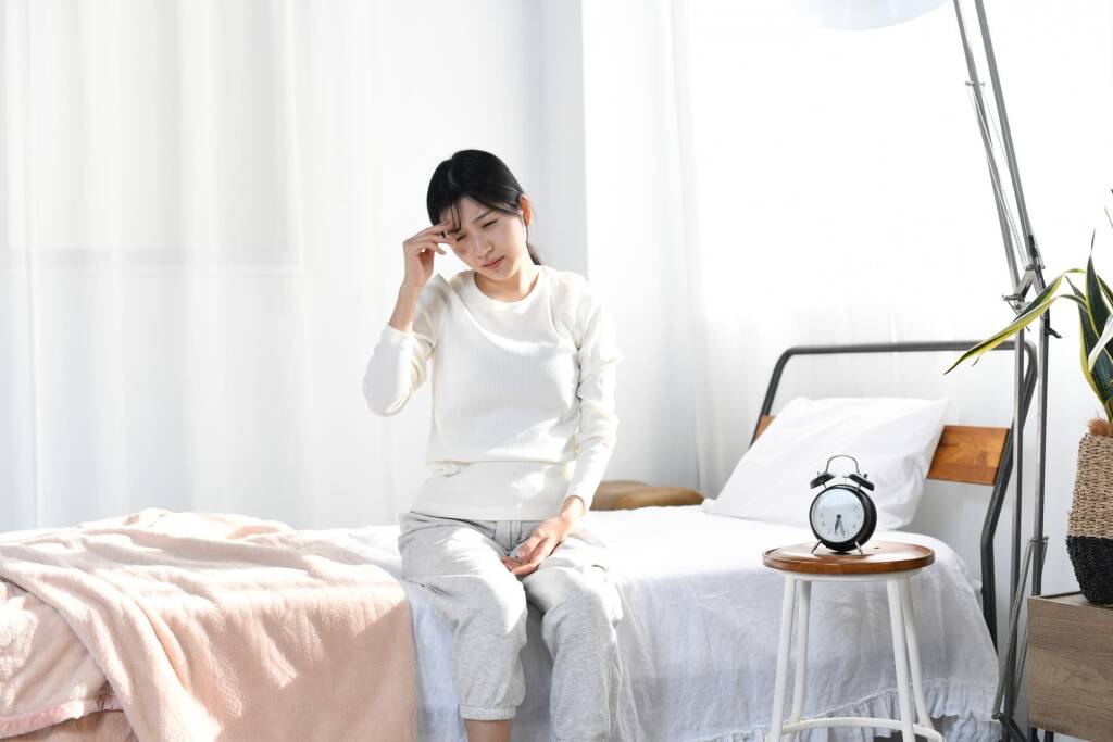 寝室で体調が悪そうな女性