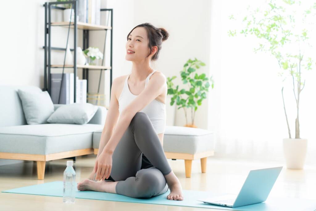 ヨガマットの上でストレッチする女性