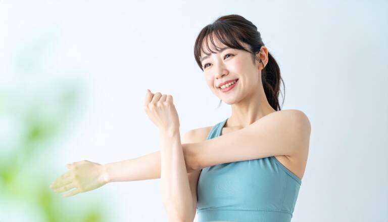 腕を伸ばして笑顔でストレッチする女性